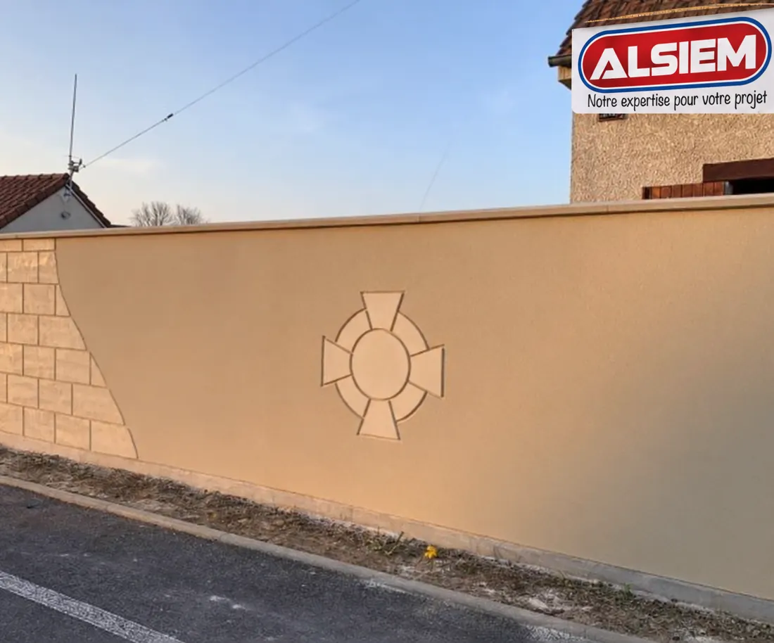 Mur de clôture enduit et motif décoratif après travaux.