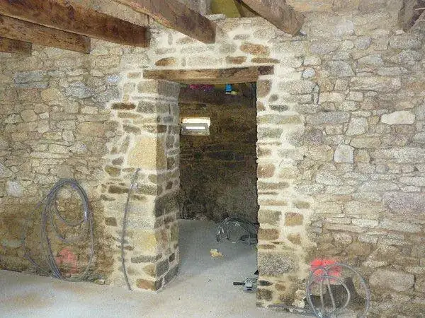 Ouverture dans un mur en pierre et mise en place du linteau.