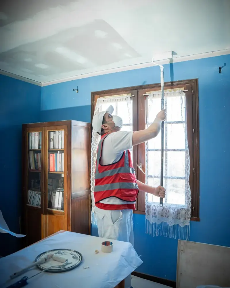 Application de peinture sur les murs d’une pièce en rénovation.