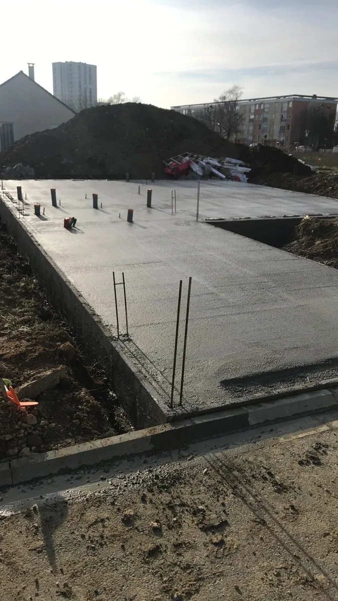 Dalle en béton après coulage, sur un chantier de construction.
