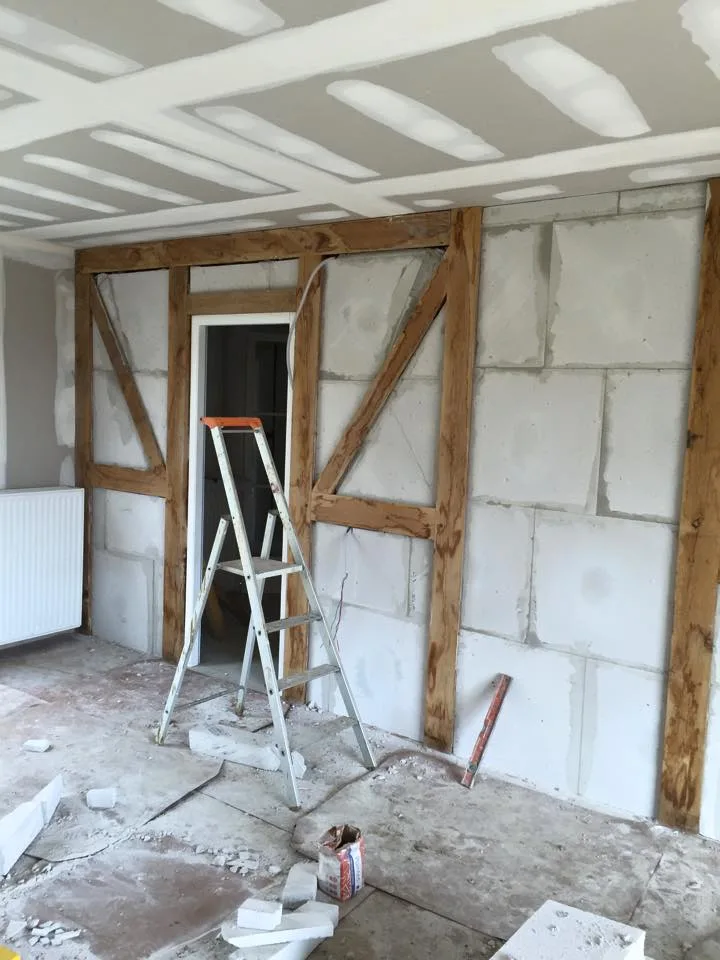 Rénovation intérieure avec structure bois existante et plafonds en plaques de plâtre.