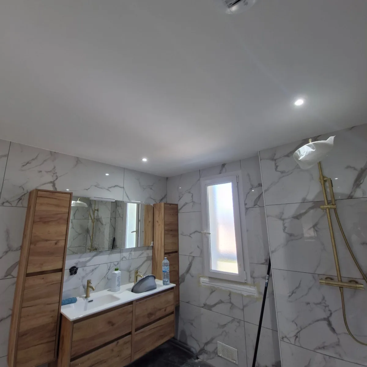 Salle de bain aménagée avec meuble vasque et revêtements muraux.
