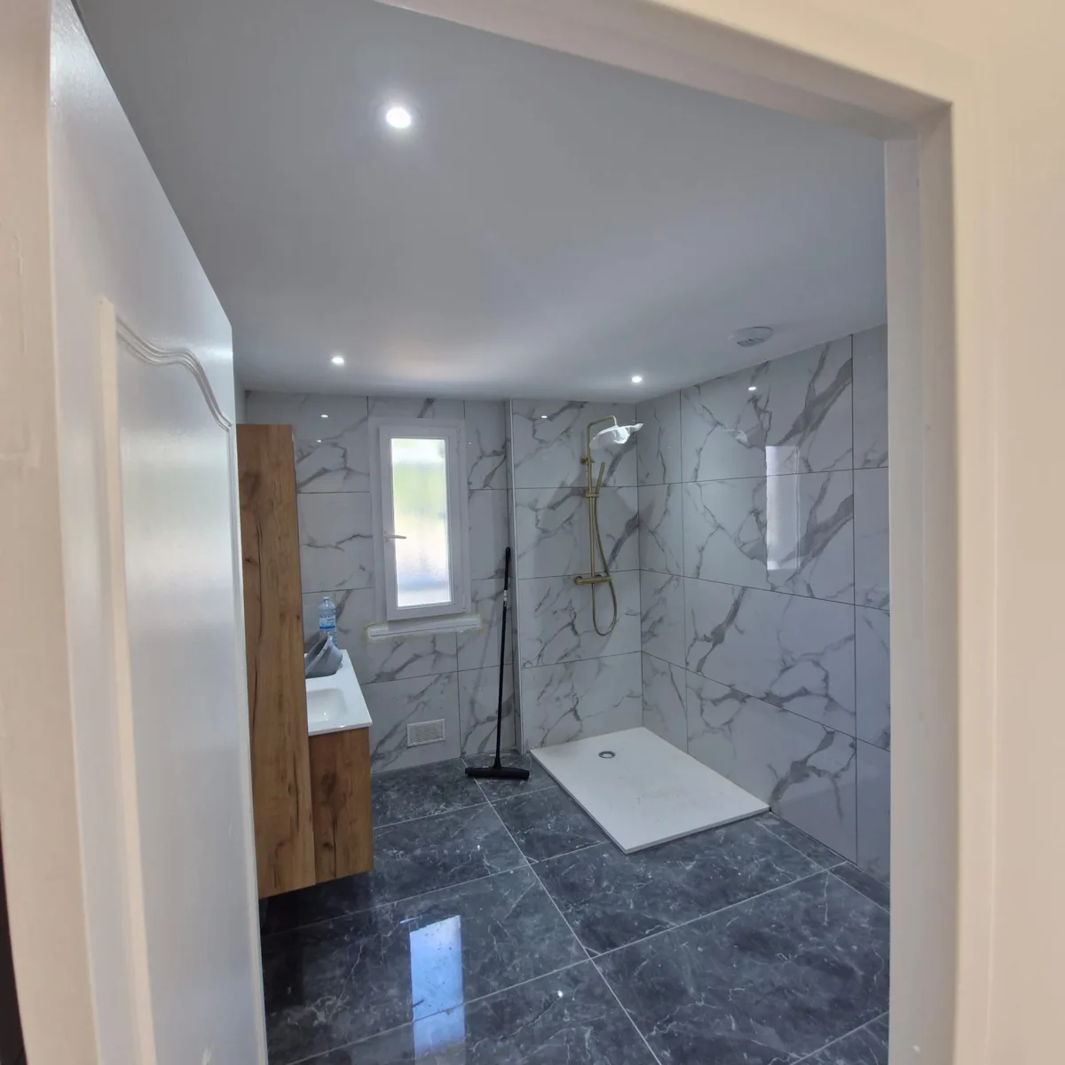 Salle de bain avec douche et revêtements de sol.
