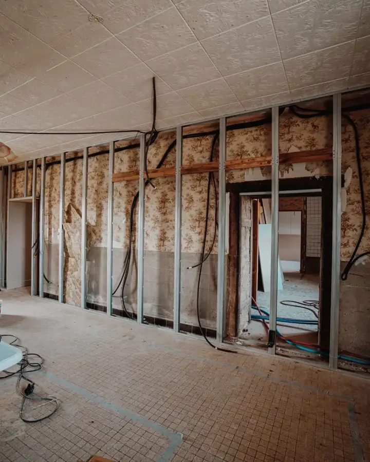 Ossatures et isolant visibles pendant une rénovation intérieure.